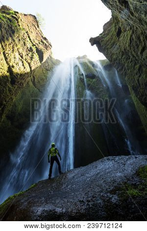 Man in the cave near the Gljufrabui waterfall, Iceland, Europe