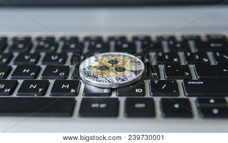 Silver Gold Ripple Coin On A Laptop Keyboard Closeup. Blockchain Mining. Digital Money And Virtual C