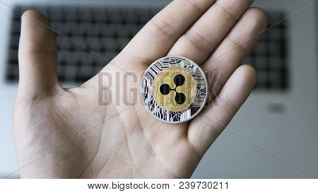 Ripple Coin On A Laptop Keyboard Closeup On A Miner Hand. Blockchain Mining. Digital Money And Virtu