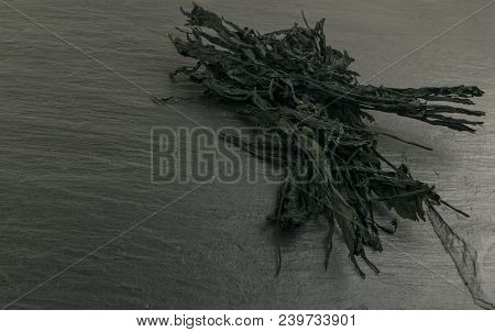 Heap Of Dry Wakame Seaweed On Black Stone Background. Healthy Algae Food With Place For Text