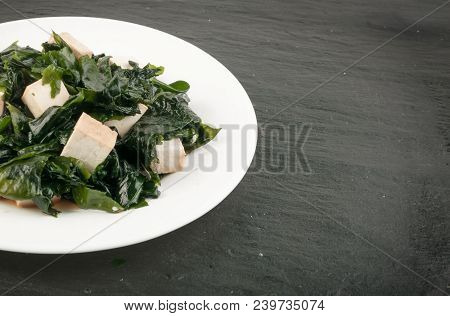 Cooked Wakame Seaweed Salad In White Bowl On Natural Stone Background. Healthy Algae Food With Soy S