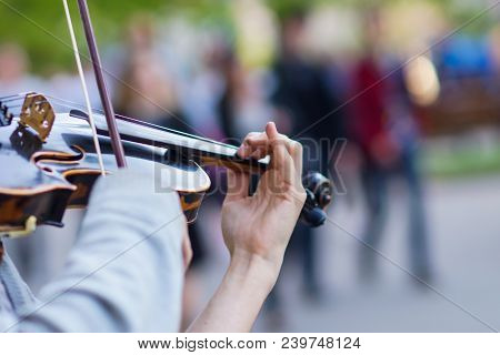 The Violin Is Big, Against The Backdrop Of The Street
