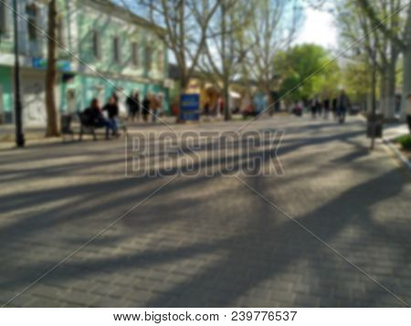 Blur Of The Spring Pedestrian Street In The Center Of A Small City At Sunset. Street, Square, Plaza.