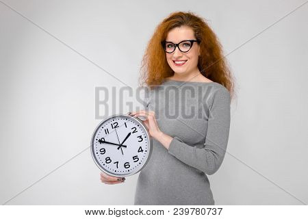 Charming Young Girl With Red Hair. A Young Girl In A Gray Sweater. Young Girl On A Gray Background.