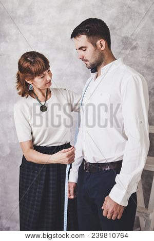 Woman Tailor Takes Measures With Male Models. Fashion Designer Sews A Costume For The Model