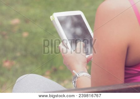 Detail Of A Woman Using Tablet In The Park.
