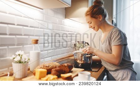 Young Woman In Pajamas Prepares Breakfast In The Morning