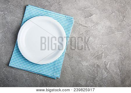 Empty White Plate With Nupkin On A Gray Stone Background