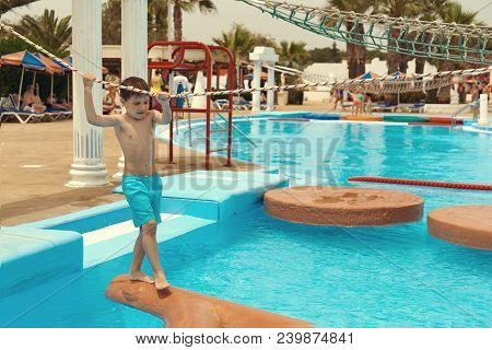 Boy Crossing Fake River With A Rope.