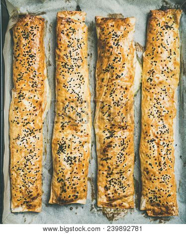 Flat-lay Of Freshly Baked Turkish Borek Pastry Rolls With Spinach, Feta Cheese And Black Cumin Seeds