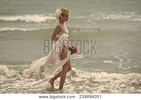 Beautiful Tender Sensual Young Bride Standing In Beage Dress In Water On Sea Beach Coast Holding Wed