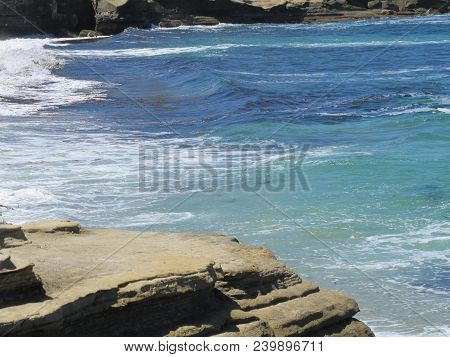 Solid Rock Shoreline At Lower Tide With A Beautiful Backdrop Of The Pacific Ocean