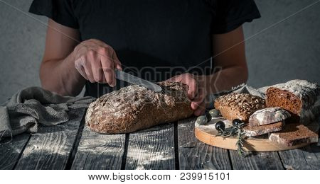 Baker Holding Fresh Bread In Hands