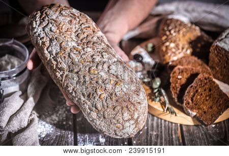 Baker Holding Fresh Bread In Hands