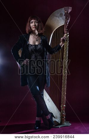 Confident Ugly Woman Wearing Black Suit Stands Near Mirrow In Front Of Camera On Stage With Crimson 