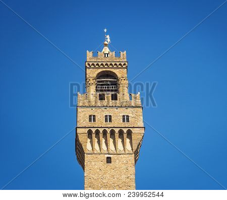 Detail Of The Bell Tower Of Palazzo Vecchio In Florence With The Large Windvane Shaped Like A Herald