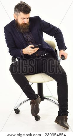 Serious Men Or Businessmen Using Mobile Or Cell Phone Sitting On Chair In Formal Outfit