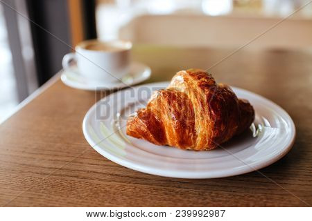 White Opened Notebook With Cup Of Cappuccino And Tasty Croissant On The Wooden Desktop. Flat Lay Sty