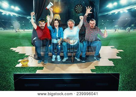 Ardent Fans Are Sitting On The Sofa And Watching Tv In The Middle Of A Football Field. Football Conc