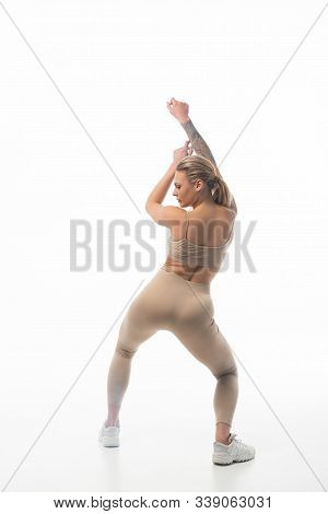 Back View Of Young Sexy Blonde Girl In Beige Leggings Twerking Isolated On White