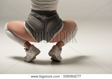 Partial View Of Young Sexy Girl In Shorts Twerking On White Background