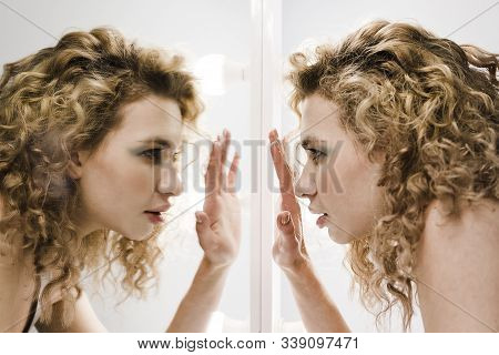 Face In Profile With Curly Blond Hair Trying To See Something Thru The Mirror