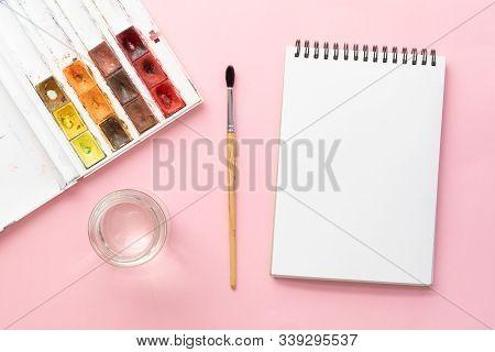 White Clean Sketchbook On Black Spring, Squirrel Brush, Jar Of Water And Watercolor Paints On Pink P