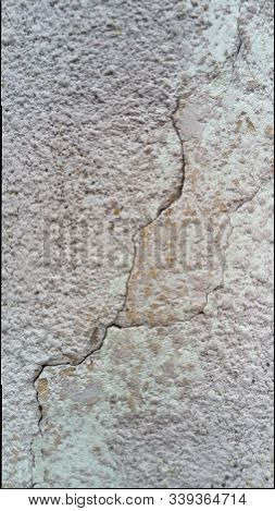Crack On The Wall Of The House. Old Plaster Falls Off The Surface. Defect During Construction. The E