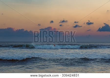 Surfing Man At Sunset In Seminyak, Bali
