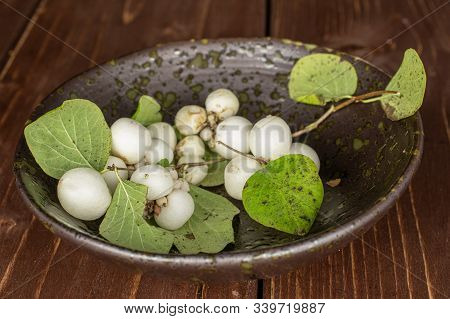 Lot Of Whole White Snowberry In Glazed Bowl On Brown Wood