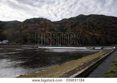 Kyoto, Japan-26 Nov, 2019: Katsuragawa River With Colourful Forest Mountain Background In Arashiyama