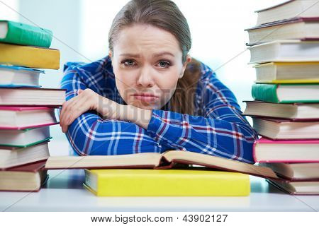 Portret student sfrustrowany jest otoczony stosy książek