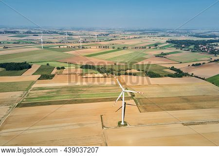 Windmill Among Agricultural Fields. Wind Turbine Generator At Summer Day. Wind Energy Concept. Suist