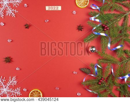 Christmas Background. Branches Of A Christmas Tree And Christmas Tree Toys On A Red Background. New 