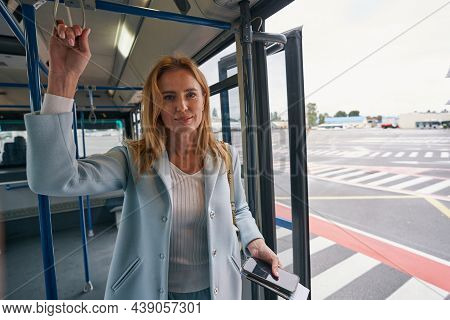 Straphanger With Travel Document Riding Airport Shuttle Bus