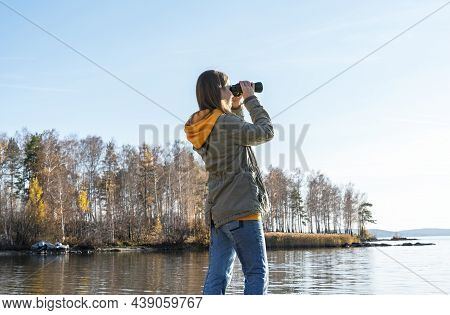 Young Woman Looking Through Binoculars At Birds On The Lake. Birdwatching, Zoology, Ecology. Researc