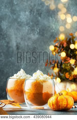 Pumpkin Latte Coffee With Wipper Cream In Glass Cups On Gray Table. Autumn Or Winter Hot Drink In Fe