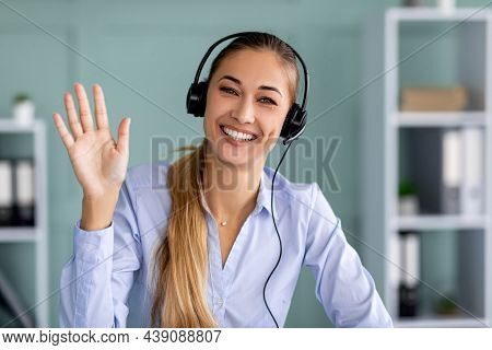 Virtual Meeting. Happy Businesswoman In Headset Making Video Call And Waving Hand Wo Webcamera
