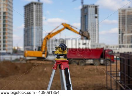 Photo Of A Level At The Construction Site Of Multi-storey Buildings With A Yellow Excavator And An R