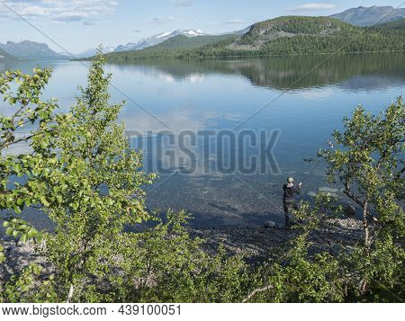 Fisherman At Lule River, In Clear Calm Lulealven Dam Lake Fresh Water In Saltoluokta In Sweden Lapla