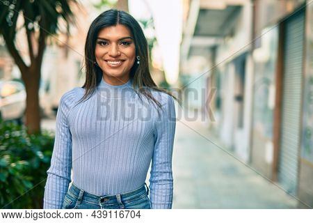 Beautiful hispanic woman smiling confient at the city