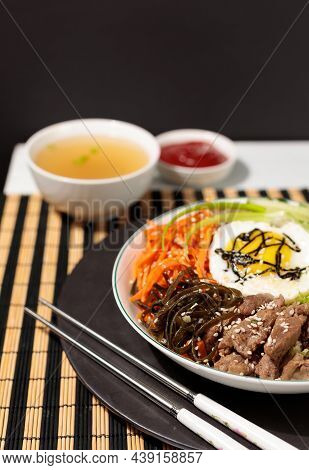 Pibimpap, One Of The Most Popular Dishes Of Korean Cuisine. Boiled Rice With Various Salads And Egg.