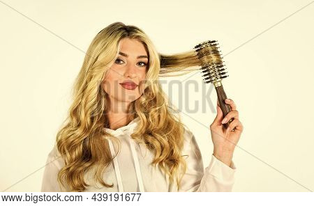 Rom Dream To Reality. Girl Care Of Hairstyle. Woman Curling Hair With Straightener. Woman Styling Ha