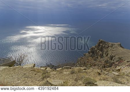 The Sun Rays Make Their Way Through The Clouds And Leave Light Spots  On The Sea Surface. View From 