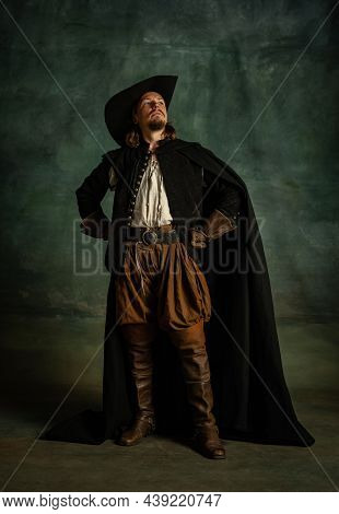 Full-length Portrait Of Genteel Brutal Man, Medeival Pirate In Hat And Cloak With Sword Isolated Ove