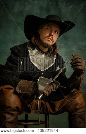 Portrait Of Brutal Horrendous Man, Medeival Pirate In Vintage Costume Sitting And Holding Sword Isol
