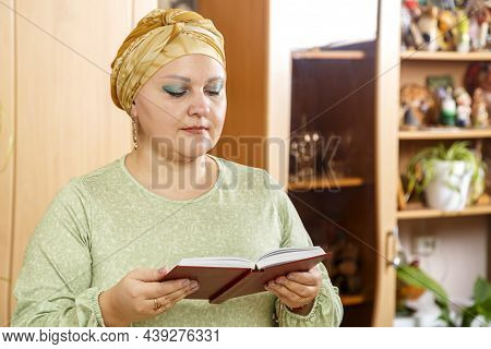 A Jewish Woman In A Traditional Turban Reads The Kabalat Shabbat Prayer Over The Siddur At The Table
