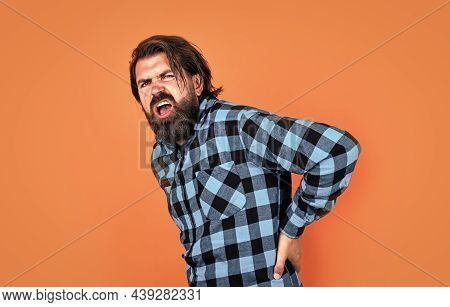 Radiculitis. Healthcare Concept. Brutal Handsome Man With Moustache. Mature Barber On Orange Backgro