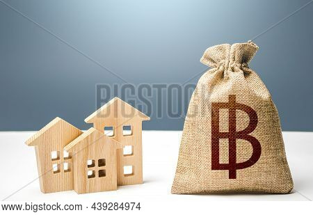 Thai Baht Money Bag And Residential Buildings. City Municipal Budget. Mortgage Loan. Costs Of Servic