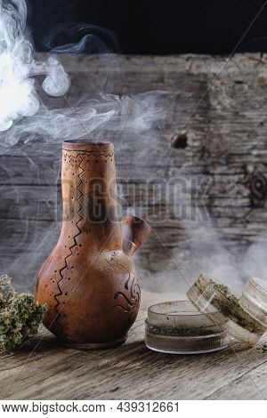 Old Brown Steamung Bong And Open Cannabis Grinder With Chopped Marijuana Weed And Medical Cannabis B